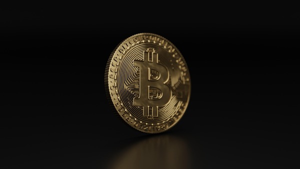 Gold Bitcoin coin standing on a dark background