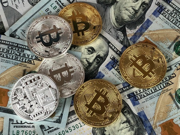 Bitcoin coins scattered on US dollar bills