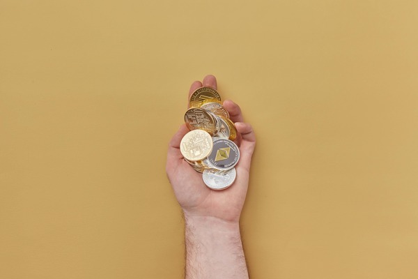 Hand holding several crypto coins