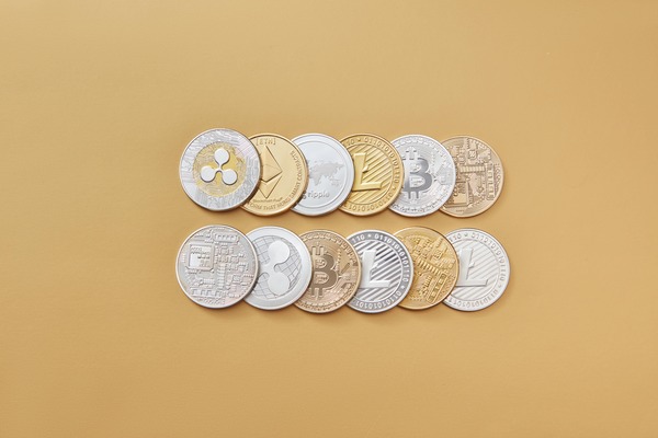 Rows of different crypto coins on a beige background