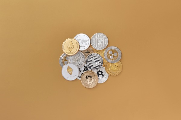 Cluster of assorted crypto coins on a beige background