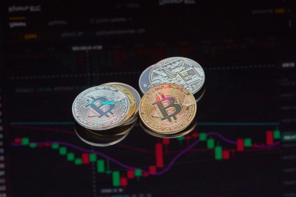 Crypto coins on a screen with a candlestick chart