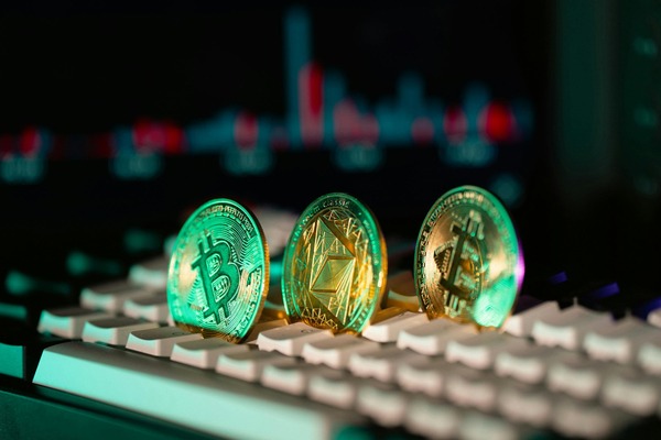 Three crypto coins standing on a backlit keyboard