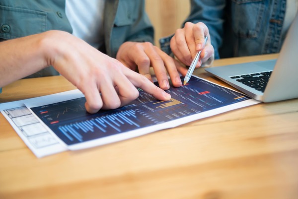 Hands pointing at a chart on a tablet