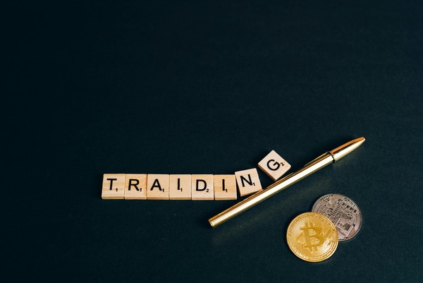 Trading letter tiles with a pen and crypto coins