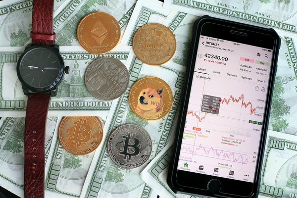 Phone with a trading app lying on dollar bills and coins