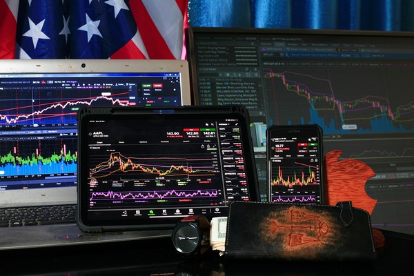 Several screens with market charts on a desk