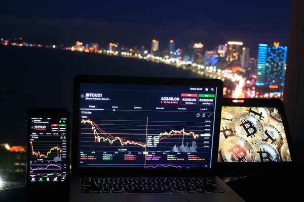 Laptop and phone with charts overlooking a city at night